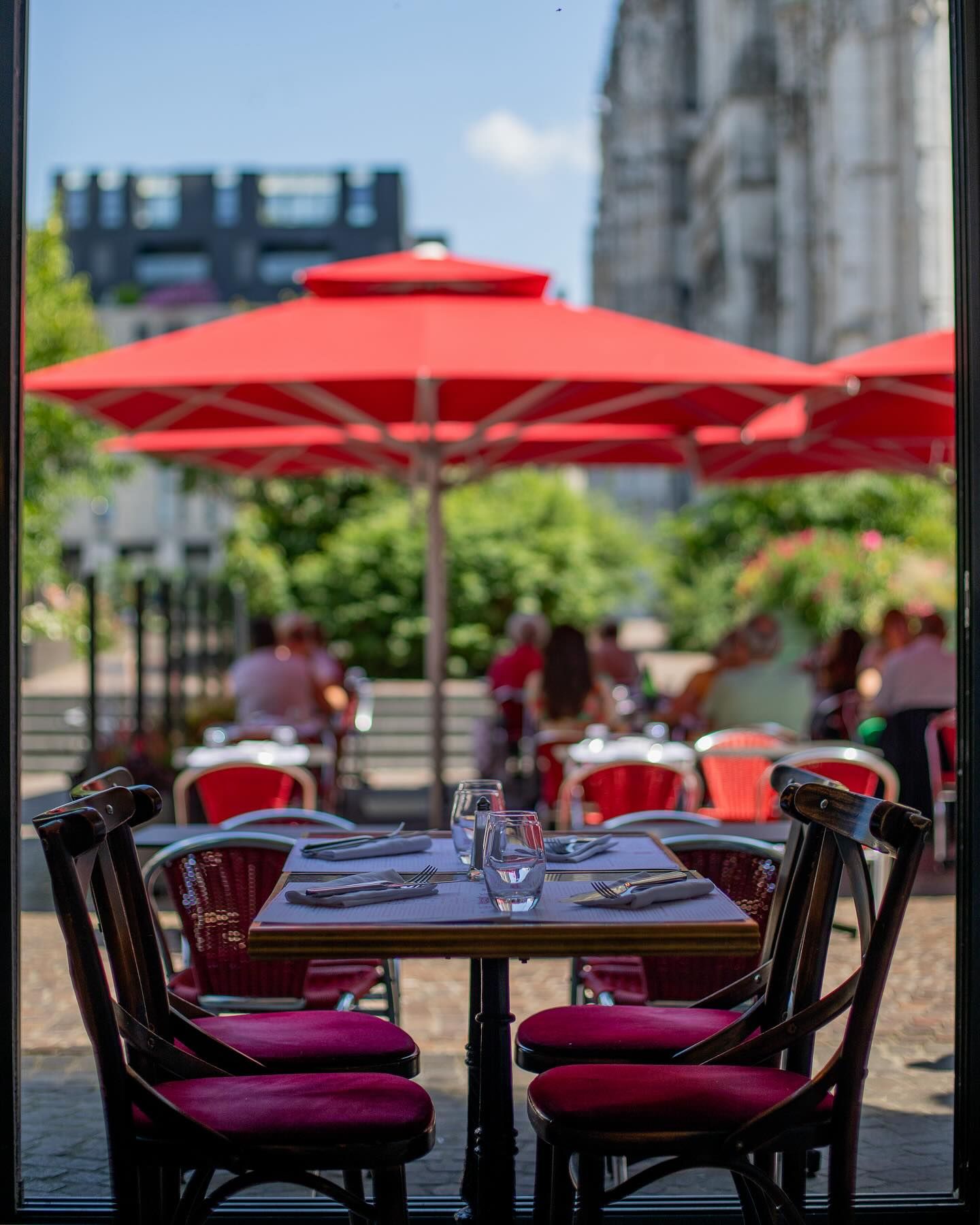 Table dressée sous les parasols rouges de la Brasserie Paul, face à la cathédrale